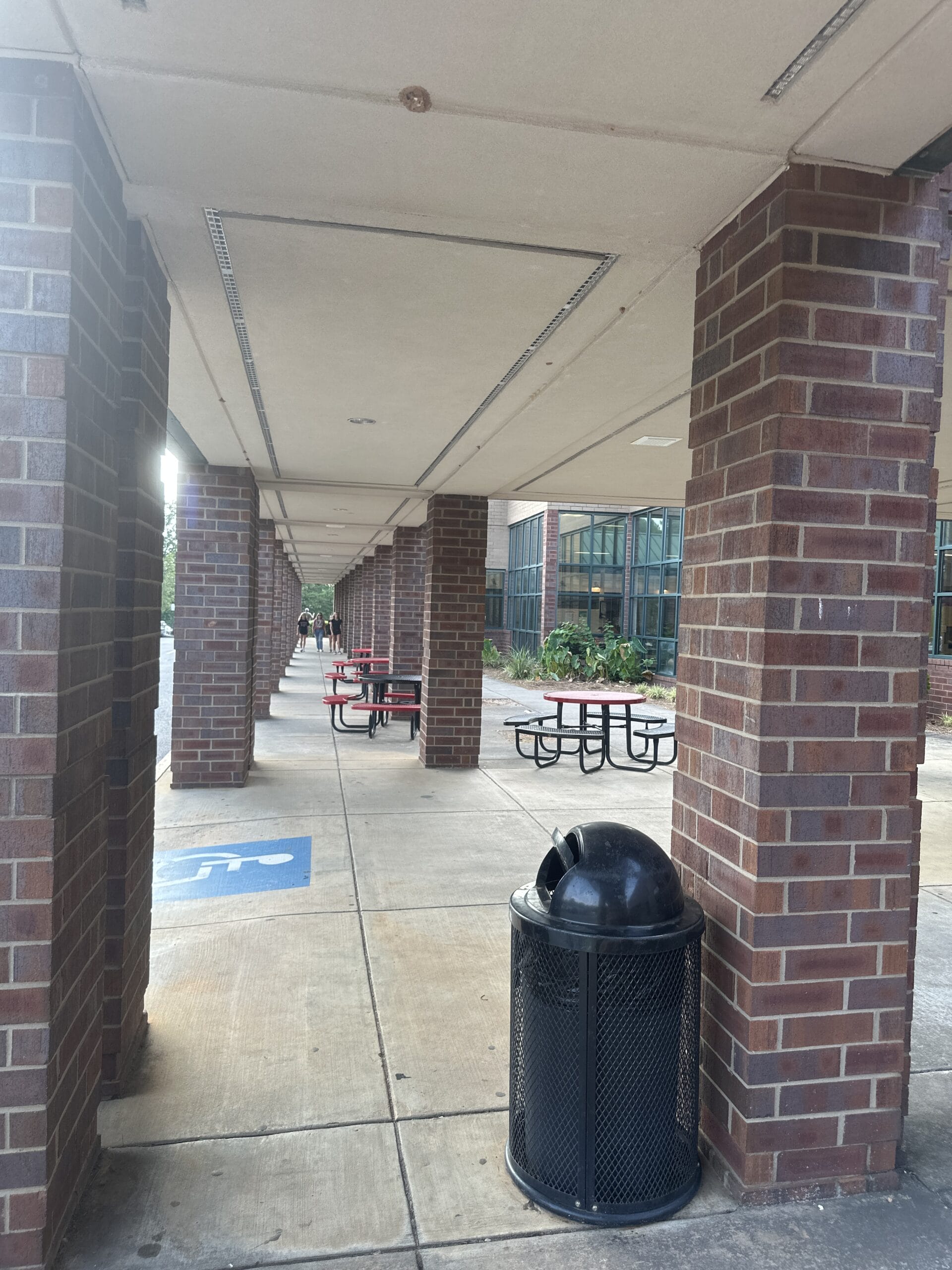 Photo of looking down a stairway with an entry point for wheelchairs, and some people walking further down.